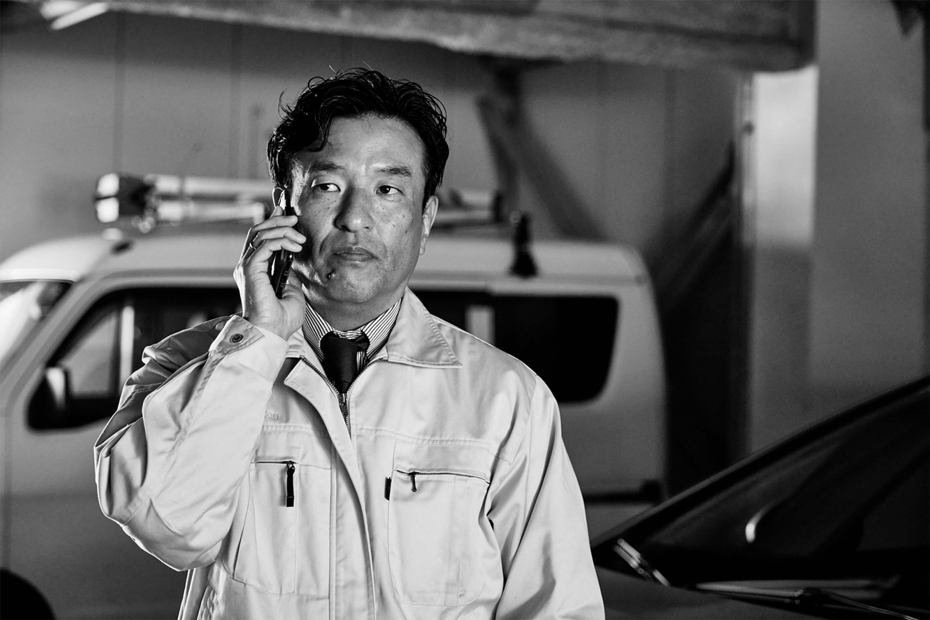 スマートフォンで電話をしている制服姿の男性