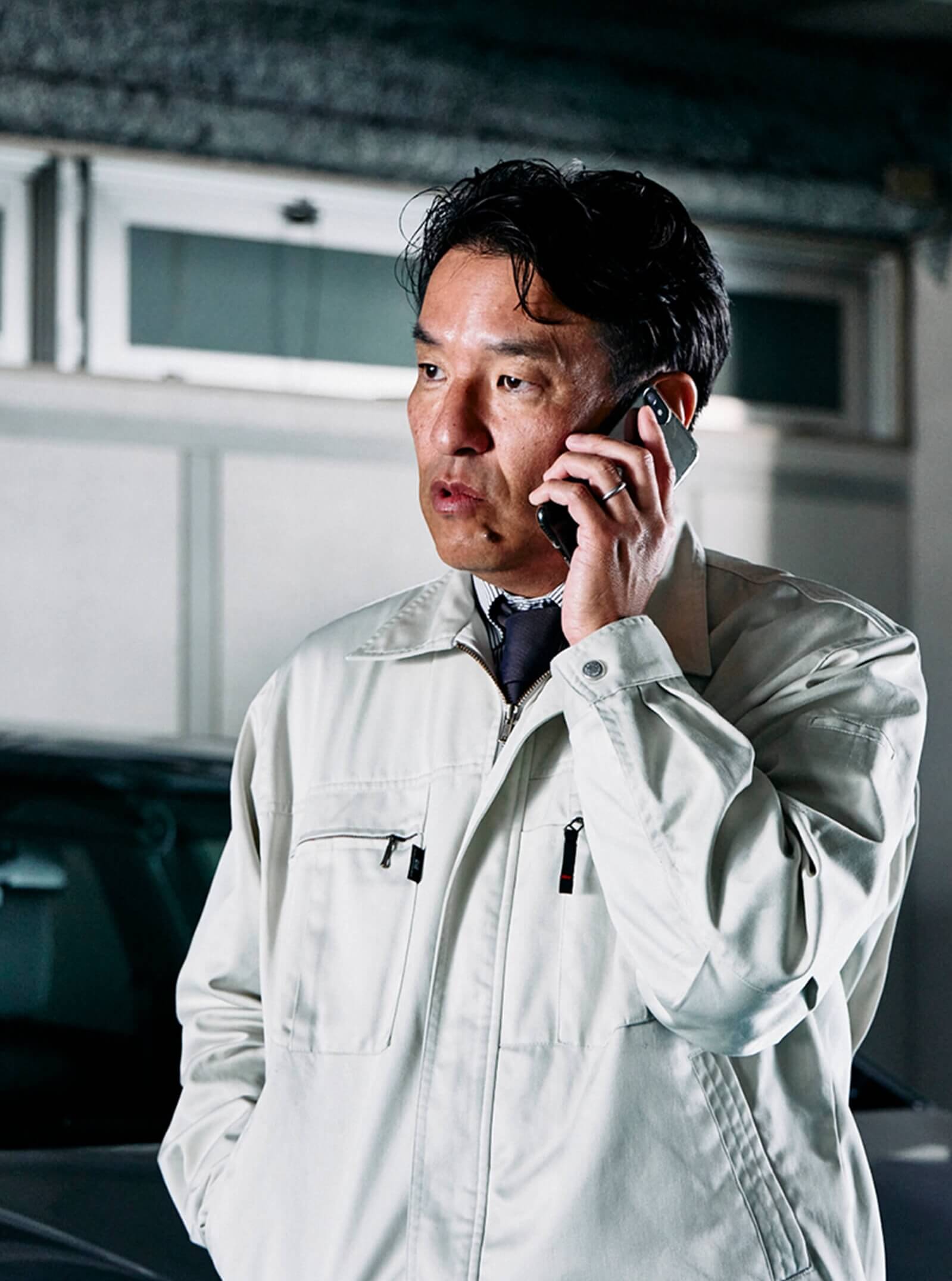 スマートフォンで電話をしている制服姿の男性