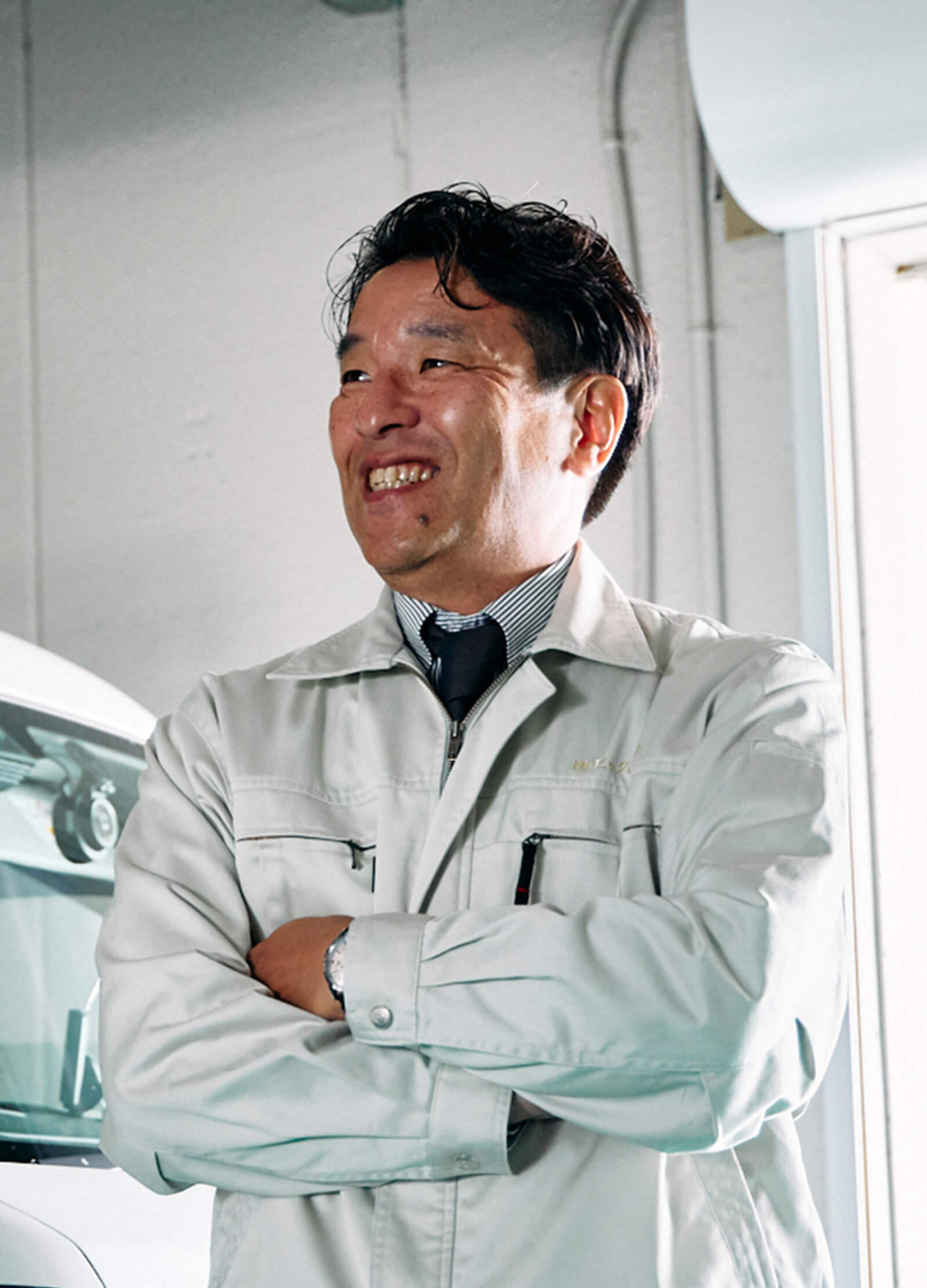 制服姿で腕を組んでいる笑顔の男性