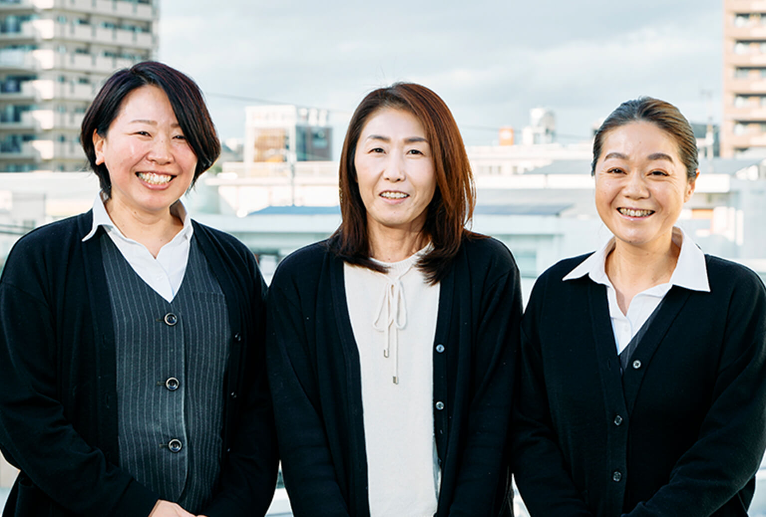 笑っている3人の女性事務員